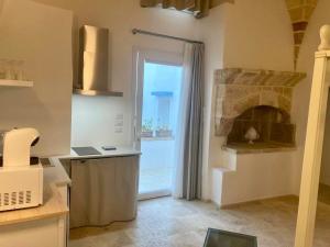 a kitchen with a large window and a fireplace at Azalea Suite Deluxe in Sannicola