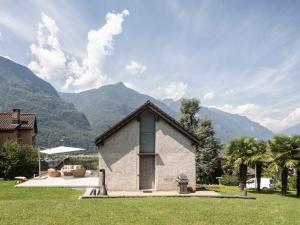 a small building in a yard with mountains in the background at Il Rustico Claro in Bellinzona