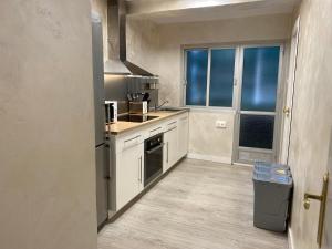 Elle comprend une petite cuisine avec des placards blancs et une fenêtre. dans l'établissement Apartamento Buensuceso 46 VFTGR04774, à Grenade