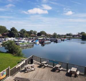 a dock with benches and boats in a marina at Billing Aquadrome Luxury Static Caravan in Great Billing