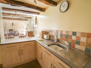 uma cozinha com um lavatório e um relógio na parede em Norton House Bed & Breakfast & Cottages em Whitchurch