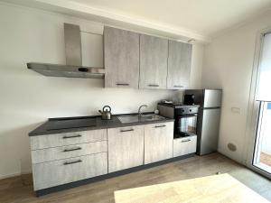 a kitchen with white cabinets and a stainless steel refrigerator at Suite Art Padova Centro in Padova