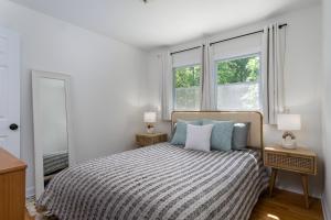 a bedroom with a bed and two windows at Nomad Retreat Pet-Friendly, Hot Tub & Mountain View in Old Fort