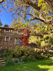 ein Backsteinhaus mit Blumen davor in der Unterkunft La Casa del Nogal in Güéjar-Sierra