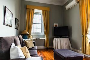 uma sala de estar com um sofá e uma televisão em Douro D'Heart - Regua Guesthouse - Casa Completa em Peso da Régua