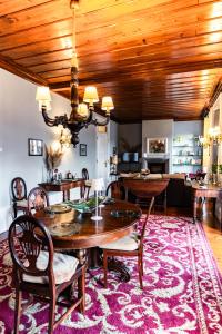 a dining room with a table and chairs on a rug at Douro D'Heart - Regua Guesthouse - Casa Completa in Peso da Régua