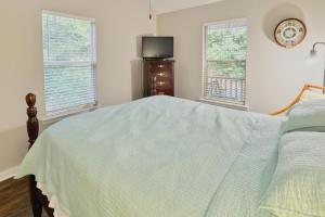 a bedroom with a bed and a tv and two windows at Laurel Creek in Helen