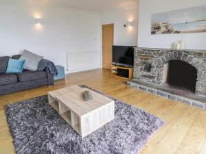 a living room with a couch and a fireplace at Hendre Wylan in Barmouth