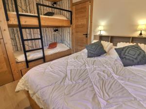 a bedroom with a bed and two bunk beds at Appartement Méribel, 3 pièces, 6 personnes - FR-1-182-243 in Les Allues