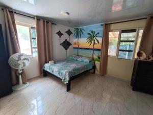 een slaapkamer met een bed en een schilderij van het strand bij Bella Marcela in Buenavista