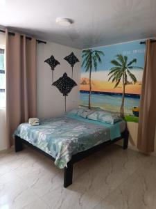a bedroom with a bed with palm trees on the wall at Bella Marcela in Buenavista