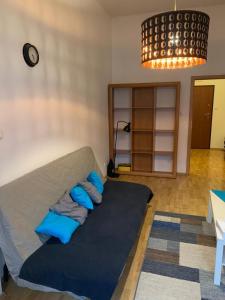 ein Sofa mit blauen Kissen im Wohnzimmer in der Unterkunft Spacious 2-rooms penthouse in Warsaw city center in Warschau