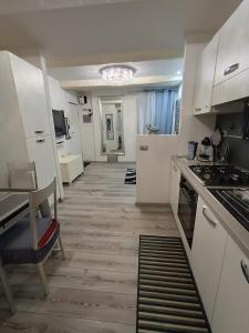 cocina con armarios blancos y suelo de madera en La Casina Pallacorda, en Prato