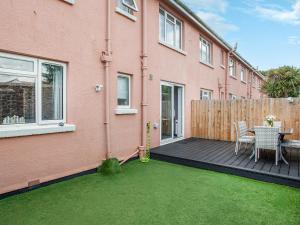 a patio with a table and chairs and a fence at Garden Apartment - Uk44654 in Paignton
