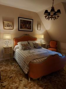 a bedroom with a large bed and two night stands at Le Jardin de Wéléat in Valognes
