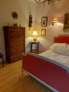 a bedroom with a bed and a dresser and a lamp at Le Jardin de Wéléat in Valognes