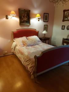 - une chambre avec un lit et deux lampes murales dans l'établissement Le Jardin de Wéléat, à Valognes