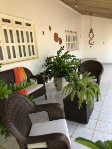 a living room with wicker chairs and potted plants at Casa com 4 quartos e área externa com jardim in São Raimundo Nonato