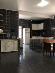 a kitchen with black tile walls and a white refrigerator at Casa com 4 quartos e área externa com jardim in São Raimundo Nonato
