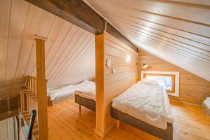 ein Schlafzimmer im Dachgeschoss mit einem Bett und einer Treppe in der Unterkunft Levillas Lammaskuru A in Levi