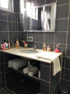 a bathroom with a sink and a mirror and towels at Casa com 4 quartos e área externa com jardim in São Raimundo Nonato