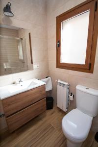La salle de bains est pourvue de toilettes, d'un lavabo et d'une fenêtre. dans l'établissement Apartamentos 7 Puentes Sierra Cazorla, à Burunchel