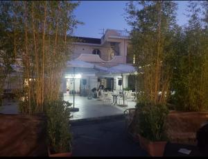 un edificio con patio attrezzato con tavoli e ombrelloni di max hotel e restaurant a Pontecagnano