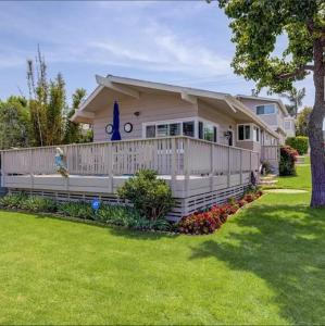 una casa con una valla y un patio en Heart of Corona Del Mar 2 Bed 2 bath gem HUGE Patio and Front yard en Newport Beach