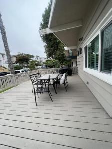 un porche con bancos y una mesa en una casa en Heart of Corona Del Mar 2 Bed 2 bath gem HUGE Patio and Front yard en Newport Beach