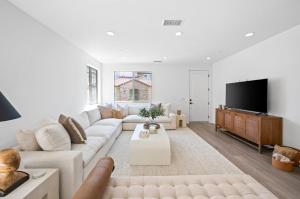a white living room with a couch and a tv at BRAND NEW La Quinta Home in Signature at PGA West in La Quinta