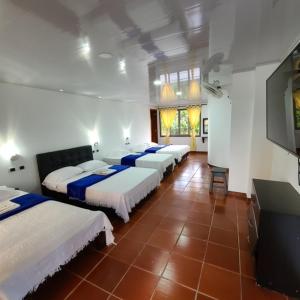 um quarto com 4 camas e uma televisão de ecrã plano em Villa Bernal em Ulloa