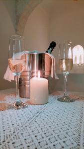 two glasses and a candle on a table with a bottle of wine at Dimore di Gio' Luxury Private Wellness Spa in Ostuni