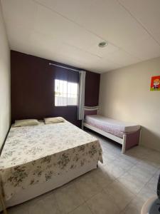 een slaapkamer met 2 bedden en een raam bij Nosso aconchego in Piranhas