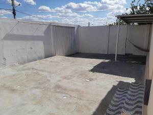 a backyard with a white fence and a concrete patio at Nosso aconchego in Piranhas