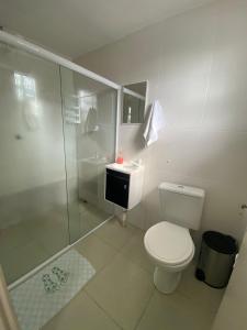 een witte badkamer met een toilet en een douche bij Nosso aconchego in Piranhas