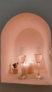two glasses of wine and a candle on a shelf at Dimore di Gio' Luxury Private Wellness Spa in Ostuni