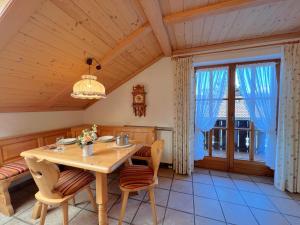 uma sala de jantar com uma mesa de madeira e cadeiras em Ferienwohnung Ferienidyll am Forrgensee em Schwangau