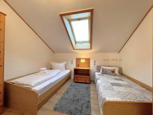 2 camas num quarto no sótão com uma janela em Ferienwohnung Ferienidyll am Forrgensee em Schwangau