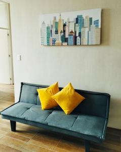 ein blaues Sofa mit zwei gelben Kissen im Wohnzimmer in der Unterkunft 3J's House in Tarapoto