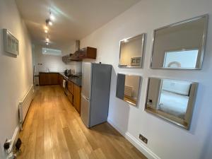a kitchen with a refrigerator and some windows at Stylish Traveller's Heaven in London