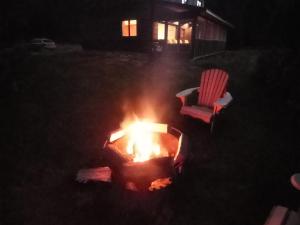 una hoguera en el patio por la noche con una silla en Private Country Retreat on 80 acres 