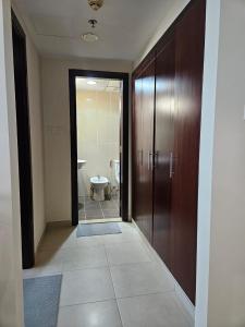 a hallway with a bathroom with a toilet and a door at Lakeshore Towers, Cluster Y , JLT, 1BHK in Dubai