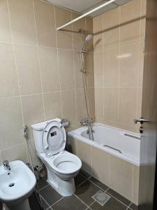 a bathroom with a toilet and a tub and a sink at Lakeshore Towers, Cluster Y , JLT, 1BHK in Dubai +8 photos