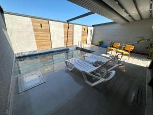 uma vista superior para uma piscina com cadeiras e uma mesa em Özel Havuzlu Muhteşem Villa em Aksu