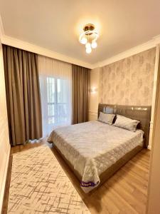 1 dormitorio con cama y ventana grande en Элитная квартира возле площади, en Shymkent