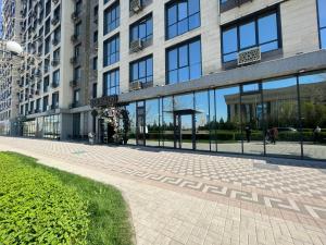 a large building with a walkway in front of it at Элитная квартира возле площади in Shymkent