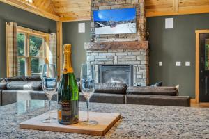 a bottle of wine on a table with two wine glasses at Ski Chalet 6 min to Sunday River - Hot Tub, Home Theater, Game Room, Fire Pit - Sleeps 12 in Bethel