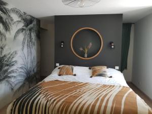 um quarto com uma cama com um espelho na parede em gîte la vie en couleur 14 personnes em Saint-Paul-en-Gâtine