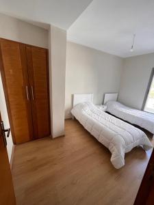 um quarto com 2 camas e uma grande janela em Chez khadija et Othman em Tânger