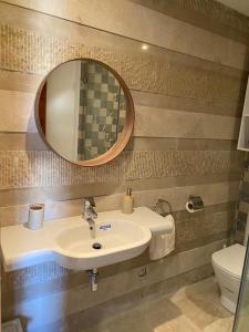 uma casa de banho com um lavatório, um espelho e um WC. em Chez khadija et Othman em Tânger